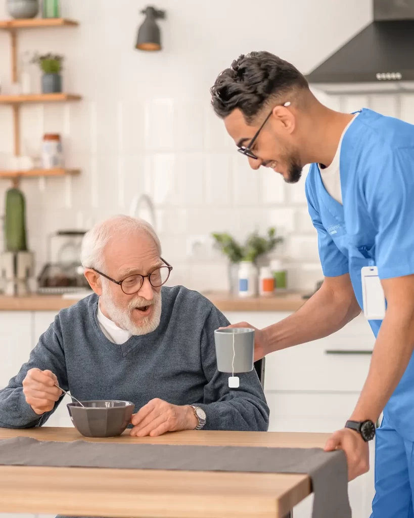 Caregiver serving a cup of tea to a person, offering comforting and attentive care
